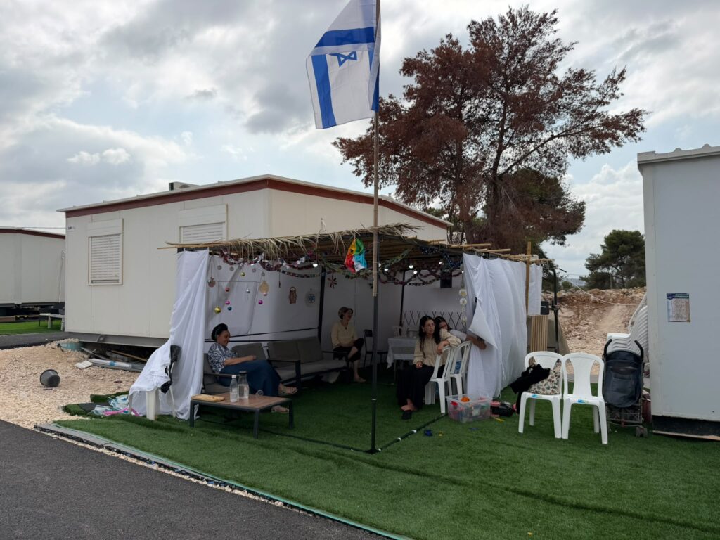 Families in the Jewish community of Kadim celebrate Sukkot, with a temporary Sukkah next to their mobile homes, which will soon become permanent buildings
